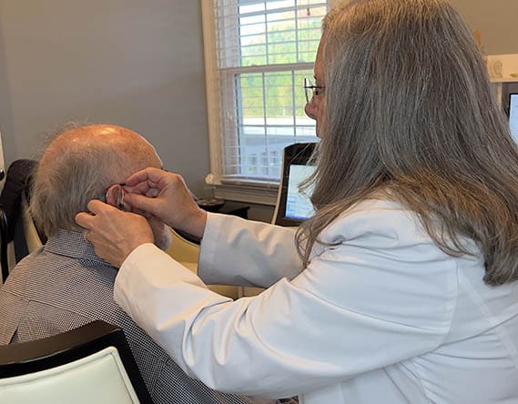 Elderly Patient Getting Hearing Aid Fitted at Hearing & Balance Clinics